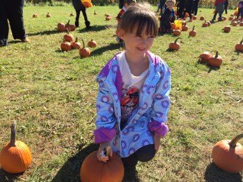 Emma Picking Her Pumpkin at the Farm