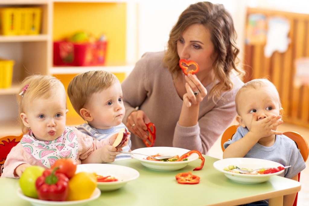 kids eating healthy food in kindergarten, nursery or at home